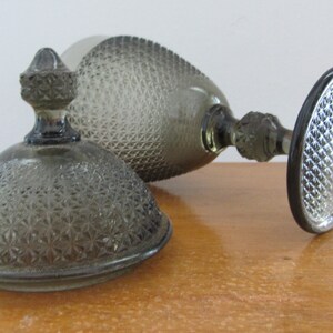 May include: A clear glass candy dish with a domed lid. The dish and lid have a textured, diamond-shaped pattern.