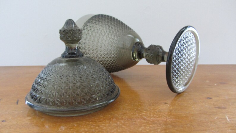 May include: A clear glass candy dish with a domed lid. The dish and lid have a textured, diamond-shaped pattern.