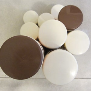 May include: A set of eight round containers with alternating white and brown lids. The containers are stacked in a pyramid shape.
