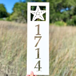 May include: White wooden sign with a cutout of a starfish and the numbers 1714.