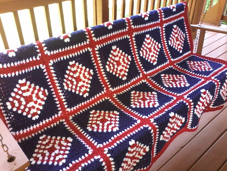 Pu&ograve; includere: Una coperta all'uncinetto in rosso, bianco e blu con un motivo a rombi. La coperta &egrave; realizzata in filato ed &egrave; perfetta per un divano o un letto.