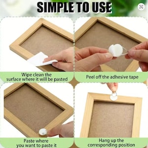 May include: A guide with the text "SIMPLE TO USE" demonstrates how to hang a picture frame. The steps include cleaning the surface, removing adhesive tape, pasting, and hanging the frame. The frame is made of light brown wood.