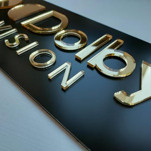 Peut inclure: Un panneau rectangulaire noir avec l'inscription "VISION BOARD" en lettres dor&eacute;es miroir. Les lettres sont en relief et refl&egrave;tent la lumi&egrave;re, cr&eacute;ant un effet brillant. Le panneau est probablement destin&eacute; &agrave; la d&eacute;coration de la maison ou du bureau.