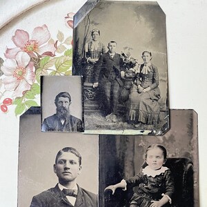 May include: A collection of antique black and white photographs. The images feature portraits of individuals and groups, showcasing vintage clothing and hairstyles. The photographs are displayed on a floral patterned surface.