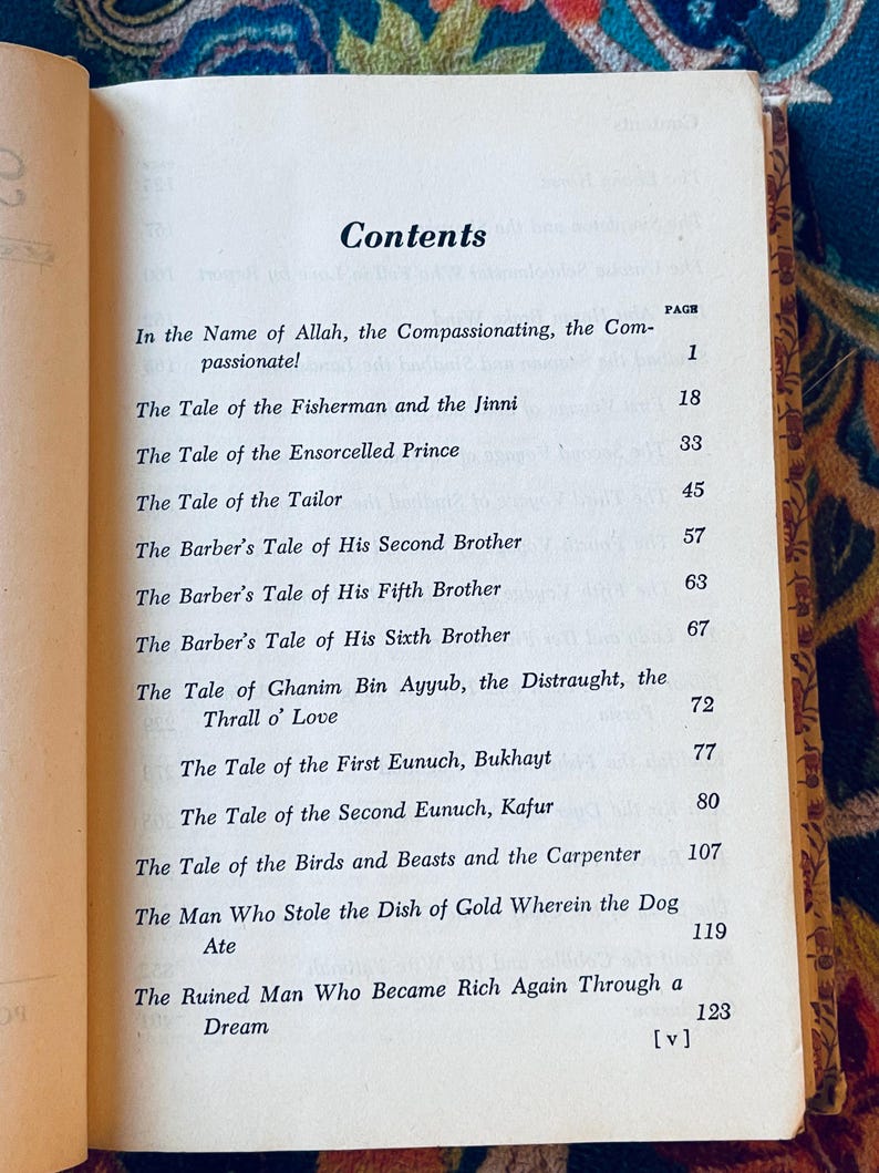 May include: Open book displaying a table of contents titled "Contents". The page is aged with a gold border and lists chapter titles such as "The Tale of the Fisherman and the Jinni" and "The Tale of the Ensorcelled Prince".