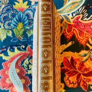 May include: A hardcover book titled "Tales From The Arabian Nights" by Burton. The spine is brown with gold lettering and decorative elements. The book is a collector's edition, with the number 36 visible.