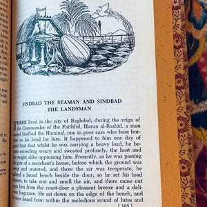 May include: Open book with a black and white illustration of a Middle Eastern scene, including a lute, palm trees, and a cityscape. The text reads "SINDBAD THE SEAMAN AND SINDBAD THE LANDSMAN". The book has decorative floral edges.