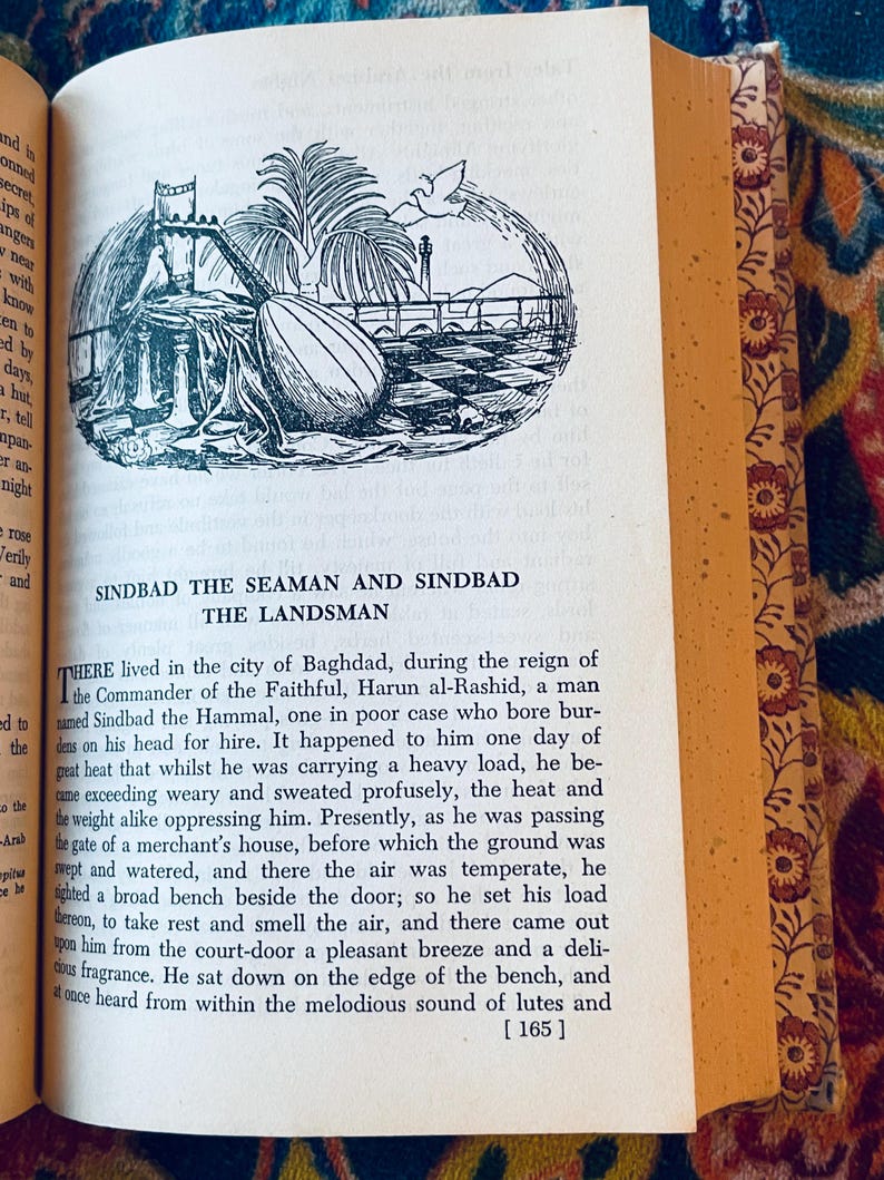 May include: Open book with a black and white illustration of a Middle Eastern scene, including a lute, palm trees, and a cityscape. The text reads "SINDBAD THE SEAMAN AND SINDBAD THE LANDSMAN". The book has decorative floral edges.