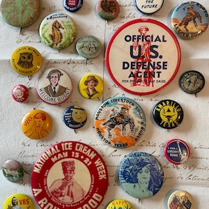 May include: A collection of vintage pinback buttons with various designs and text. The buttons feature images of a seahorse, a cowboy, an owl, and text such as "Welcome Buddy" and "National Ice Cream Week."