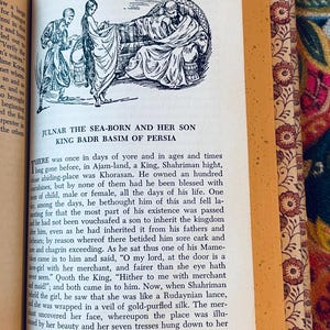 May include: Open book page with an illustration of three figures in a Middle Eastern setting. The text reads "JULNAR THE SEA-BORN AND HER SON KING BADR BASIM OF PERSIA" with additional text below. The book's edge has a floral pattern.