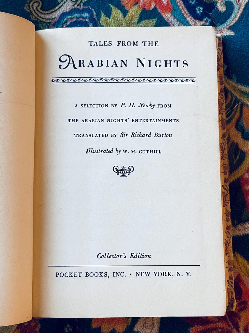 May include: Open book with the title "Tales From The Arabian Nights" in a decorative font. The text includes the author's name, translator, and illustrator. The book is a Collector's Edition published by Pocket Books, Inc., New York, N.Y.