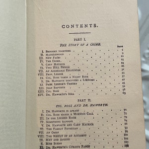 May include: A black and white book with the title "CONTENTS" printed on the cover. The book is open to a page with a list of chapter titles and page numbers. The chapters are divided into two parts: "The Story of a Crime" and "Col. Ross and Dr. Haworth".