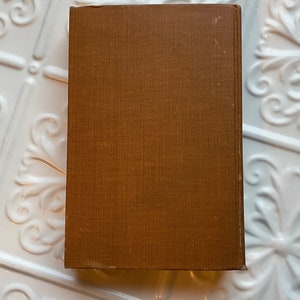 May include: A brown hardback book with a textured cover.