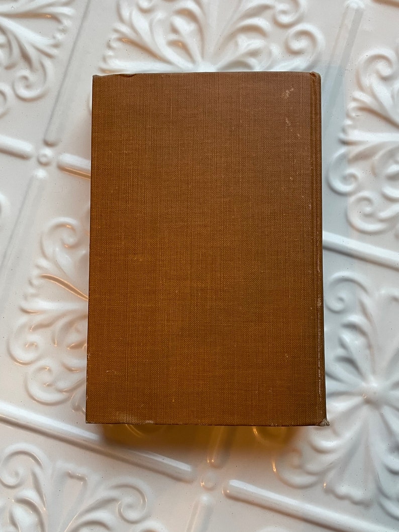 May include: A brown hardback book with a textured cover.