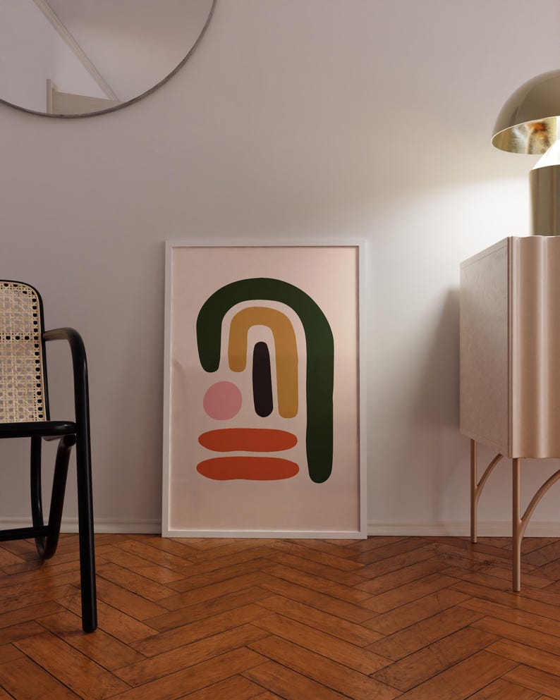 May include: A framed abstract art print with a white border. The artwork features a design of colorful shapes, including a green arch, a yellow arch, a black vertical rectangle, a pink circle, and two orange horizontal lines, set against a light pink background.