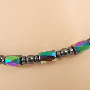 May include: A black and iridescent bracelet with alternating round and rectangular beads.