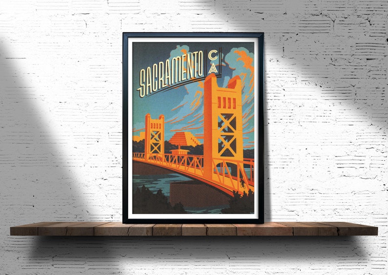 May include: A vintage travel poster featuring a stylised illustration of the Tower Bridge in Sacramento, California. The poster is in a retro style with a blue, orange and yellow colour scheme. The text "Sacramento CA" is displayed at the top of the poster.
