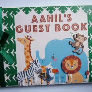 Puede incluir: Un libro de visitas personalizado con el nombre "Aahil" en letras marrones. La portada presenta un tema de jungla verde y blanco con ilustraciones de una jirafa, una cebra, un elefante, un mono, un le&oacute;n y un tuc&aacute;n. Una cinta verde est&aacute; atada en el lomo.