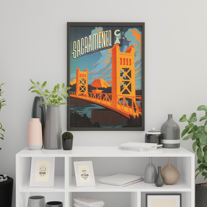 May include: A vintage-style poster featuring a yellow bridge with the text "Sacramento CA" in a retro font. The bridge is set against a blue sky with clouds and a river below.