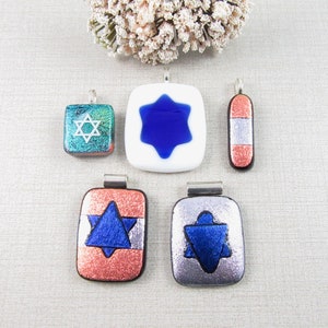 May include: Five glass pendants with silver-toned metal bail loops. The pendants feature a blue star of David design on a white, silver, or copper background.