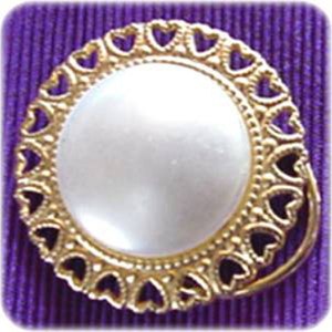 May include: A gold-toned brooch with a white pearl-like center surrounded by a heart-shaped design.