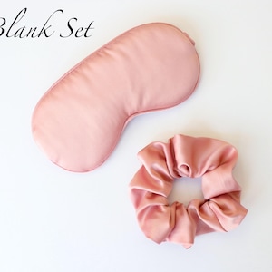 May include: A blush pink sleep set featuring a satin eye mask and a matching scrunchie. The eye mask is contoured for comfort. The scrunchie is gathered and made of the same satin material. The words "Blank Set" are in the upper left corner.