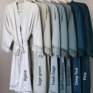 May include: Six satin robes in various shades of green and teal, with lace trim. The robes are labelled "Agave", "Sage green", "Fresh Sage", "Soft Eucalyptus", "Eucalyptus", "Deep Teal", and "Pine".