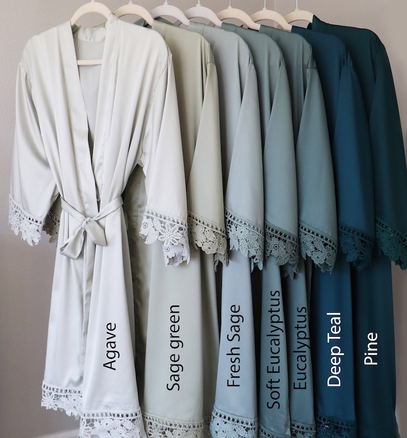 May include: Six satin robes in various shades of green and teal, with lace trim. The robes are labelled "Agave", "Sage green", "Fresh Sage", "Soft Eucalyptus", "Eucalyptus", "Deep Teal", and "Pine".