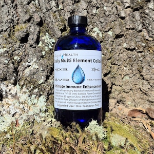 May include: A dark blue glass bottle with a black cap, labeled "Daily Multi Element Colloi" and "Ultimate Immune Enhancement." The label features a blue water droplet graphic. The bottle is set against a textured tree trunk background.