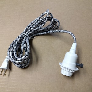 May include: Black and white patterned electrical cord with a white plug and a white light socket.