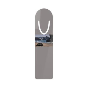Puede incluir: Un marcapáginas rectangular vertical con un borde superior redondeado y una ranura troquelada en forma de U. El marcapáginas es de color gris sólido y presenta una impresión fotográfica rectangular horizontal de una playa con rocas y olas.
