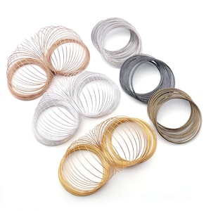 May include: A selection of coiled wire in metallic shades such as gold, silver, copper, and dark grey. The wires are arranged in circular bundles, demonstrating their flexibility and suitability for crafts or jewellery making.