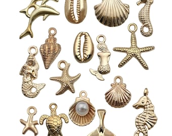 Puede incluir: Una colección de 15 abalorios de metal dorado con varios diseños de temática marina, incluyendo conchas marinas, estrellas de mar, sirenas, caballitos de mar y una tortuga.