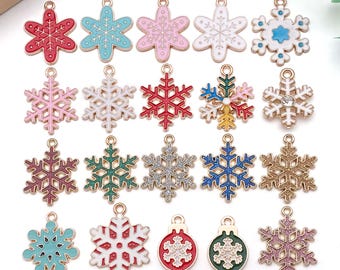 May include: A collection of colorful snowflake charms in various colors, including red, blue, pink, and gold. Each charm has a small loop for attaching to jewelry or other crafts. The charms are made of metal and enamel.