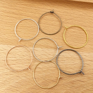 Pode incluir: Seis brincos de argola de metal de diferentes cores com fecho de pressão. As argolas são de prata, ouro, ouro rosa, preto, bronze e amarelo.