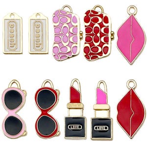 以下が含まれることがあります： エナメル細工が施されたゴールドトーンのチャームの詰め合わせ。チャームには、唇、サングラス、財布、口紅のチューブなどがあります。一部のチャームには、「ピーチ」または「ラブ」の文字が書かれています。