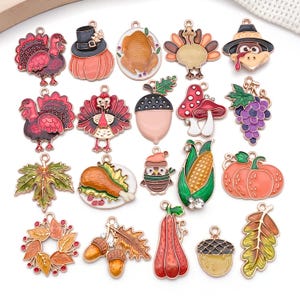 Pode incluir: Uma coleção de amuletos coloridos com tema de Ação de Graças. Os amuletos incluem perus, abóboras, bolotas, folhas e outros desenhos relacionados ao outono. Cada amuleto tem uma borda dourada e é pintado com cores brilhantes e festivas. Ideais para fazer joias ou outros projetos de artesanato.
