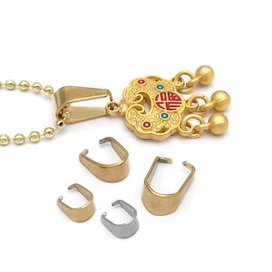 May include: Gold-coloured pendant necklace with a decorative charm featuring red, blue, and gold accents. The charm has a detailed design with a Chinese character. Several gold and silver-coloured U-shaped clasps are also shown.