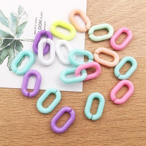 Puede incluir: Una colección de eslabones de cadena ovalados de plástico de colores vivos. Los eslabones son de varios colores pastel, incluyendo rosa, azul, verde, amarillo y morado.