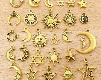May include: A collection of 24 gold-toned metal charms featuring celestial and star-shaped designs. The charms include moons, stars, suns, and a Star of David.