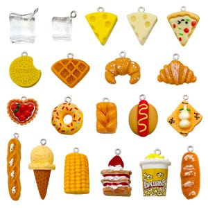 Könnte beinhalten: Eine Sammlung von Miniatur-Essensanhängern, darunter Käsescheiben, Pizza, eine Waffel, Croissant, Donut, Hotdog und Popcorn. Weitere Anhänger sind ein Keks, Eiswürfel, eine Erdbeertarte, Brot, ein Eis, Mais, ein Schichtkuchen und ein Baguette.
