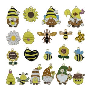 Puede incluir: Surtido de 20 abalorios de esmalte con abejas, panales, girasoles, margaritas, gnomos y tarros de miel. Los abalorios son de color dorado con detalles en amarillo, negro, blanco y marrón.