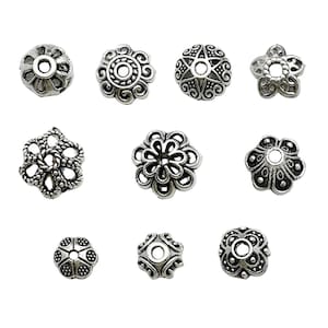May include: Assortment of 10 silver-toned metal bead caps with various ornate designs. The bead caps are round, square, and star-shaped.