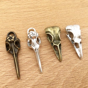 Può includere: Quattro ciondoli a forma di teschio di uccello in argento e bronzo con dettagli intricati. I ciondoli sono perfetti per la creazione di gioielli, lo scrapbooking e altri progetti di artigianato.