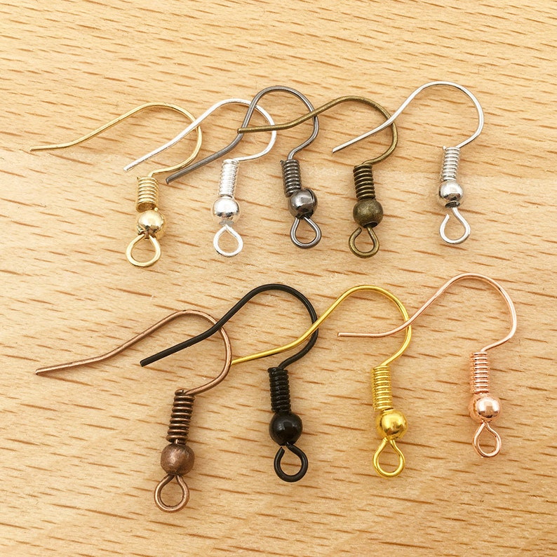 May include: Assortment of earring hooks in various colours, including silver, gold, black, bronze, and rose gold. Each hook features a spring coil and a small ball at the end.