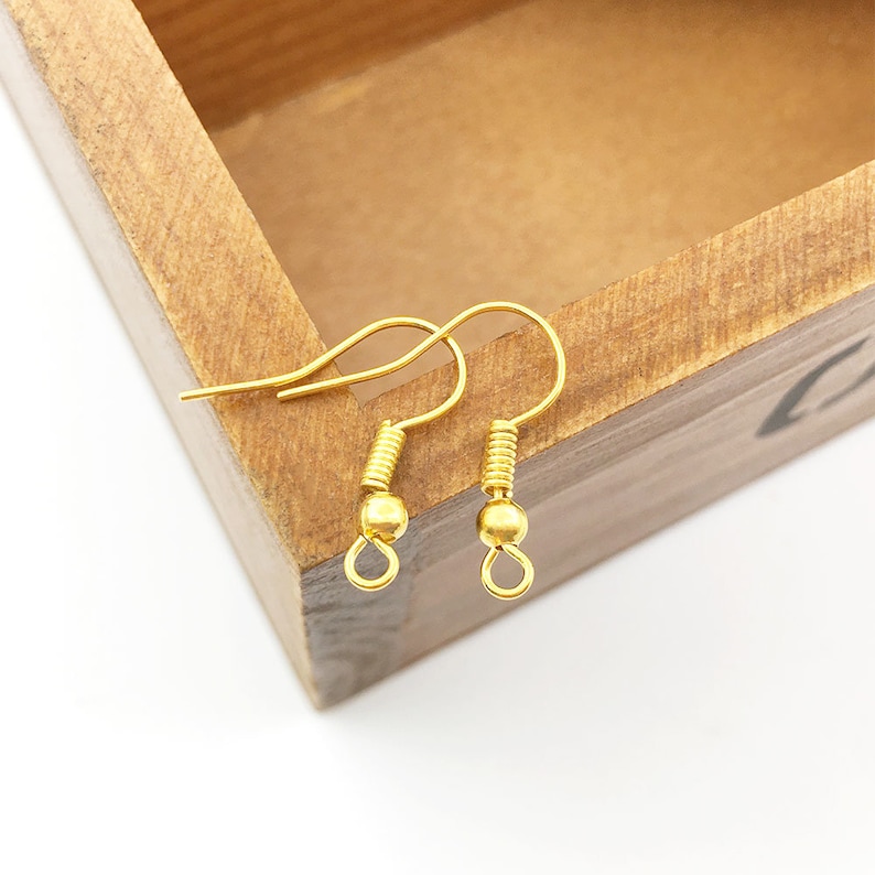 May include: Two gold-toned earring hooks with a small ball at the end of each hook.