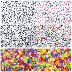 May include: Assortment of alphabet letter beads in various styles.  The beads are white with black lettering, white with colorful lettering, white with black lettering in a cube shape, and clear with colorful lettering in a cube shape.