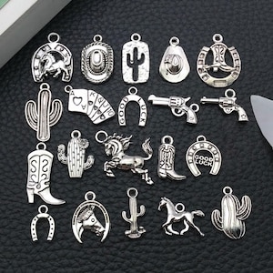 Può includere: Una collezione di ciondoli argentati a tema western, tra cui cappelli da cowboy, stivali, ferri di cavallo, cactus, carte da gioco, cavalli e pistole. Questi ciondoli dettagliati sono adatti per la creazione di gioielli o progetti artigianali.