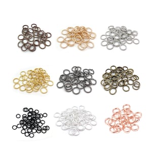 May include: Assortment of jump rings in various colors, including gold, silver, black, bronze, and rose gold. The jump rings are small and circular, perfect for jewelry making or crafting.