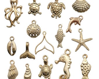 Puede incluir: Un conjunto de 15 abalorios de metal dorado con varios diseños de vida marina, incluyendo una estrella de mar, un caballito de mar, una tortuga, un pez, una concha y un pulpo.